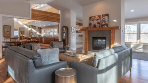 A spacious living area with a fireplace, leather sofas, and a dining area in the background. - Trinity :Sleeps 10- HotTub-GameRoom-Huge Kitchen-Perfect4Groups Tram & Mtn View (Teton Village)