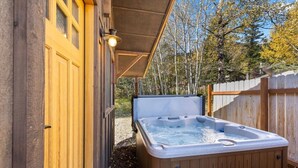 A wooden hot tub under a covered area with a wooden fence and trees in the background. - Trinity :Sleeps 10- HotTub-GameRoom-Huge Kitchen-Perfect4Groups Tram & Mtn View (Teton Village)