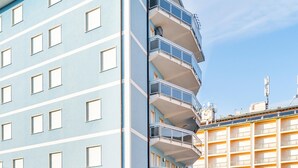 Een meerlaags gebouw met balkons en een bord waarop 