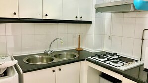 A kitchen with white cabinets, a double sink, a gas stove, and a shelf with jars. - GREAT APARTMENT FOR HOLIDAY RENT RINCON DE LOIX R059 (Benidorm)