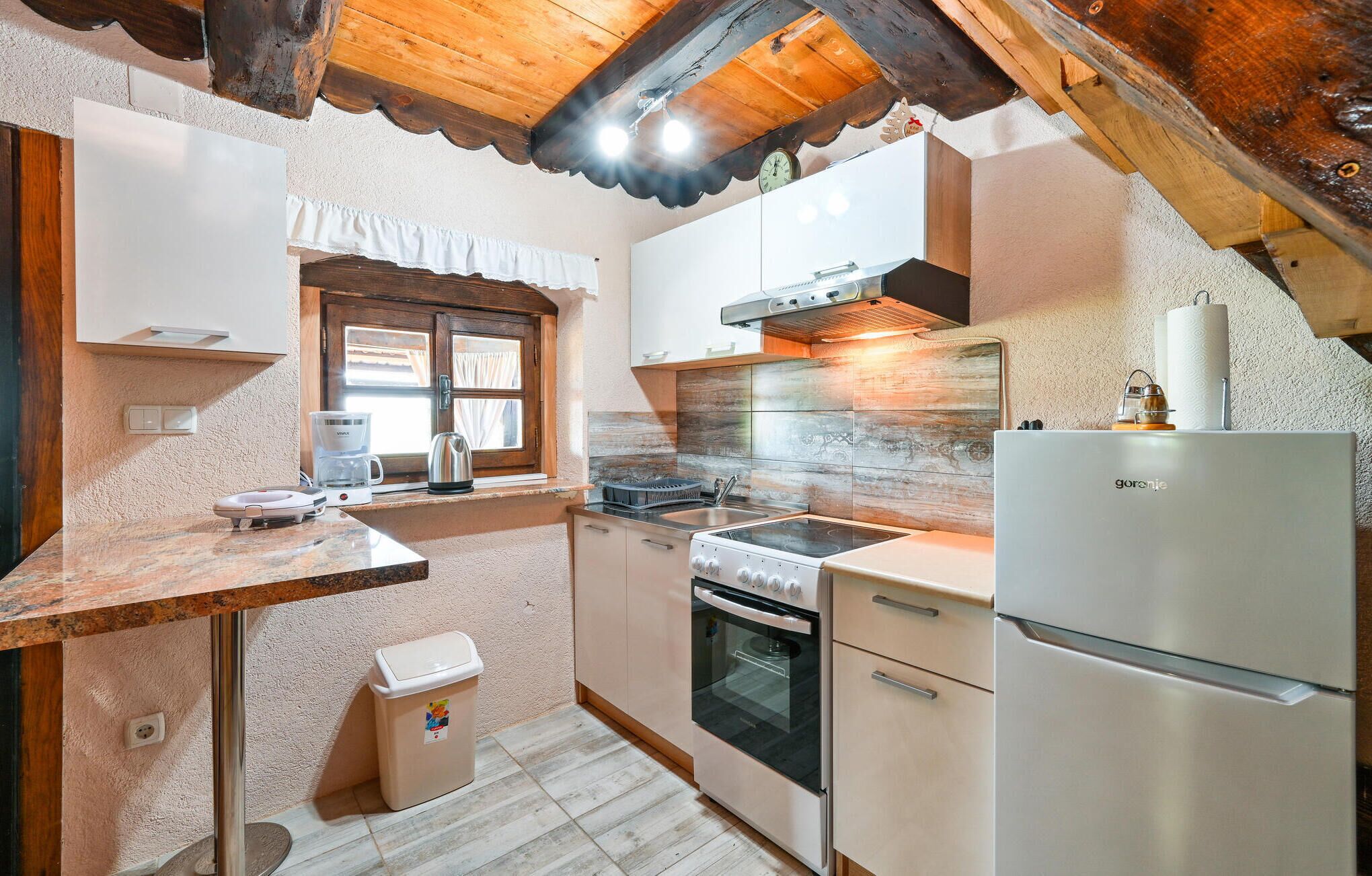 A compact kitchen with a stove, oven, and refrigerator.