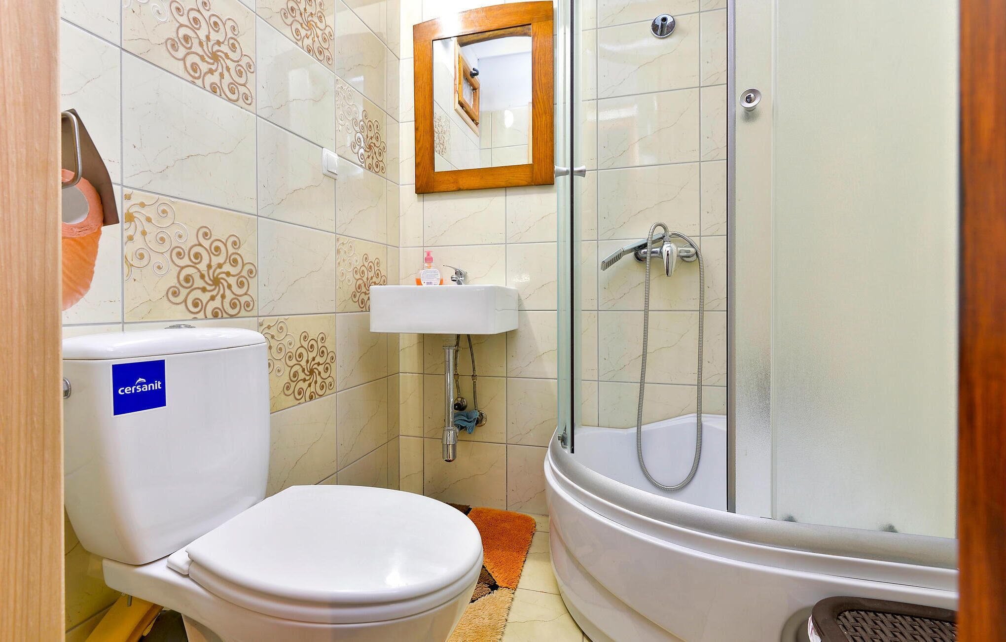Une salle de bain avec des toilettes, un lavabo et une douche.