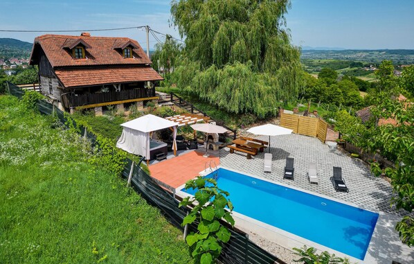 Uma casa com piscina, área de estar externa e jardim.