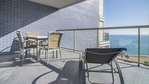 Un balcon avec vue sur l’océan, comprenant une table et des chaises.