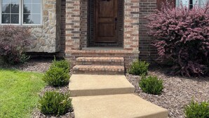 A brick house with a front porch, a wooden door, and a wreath. - Golf Getaway-Large Families Welcome! Only 10 minutes from the Airport!  (Springfield)