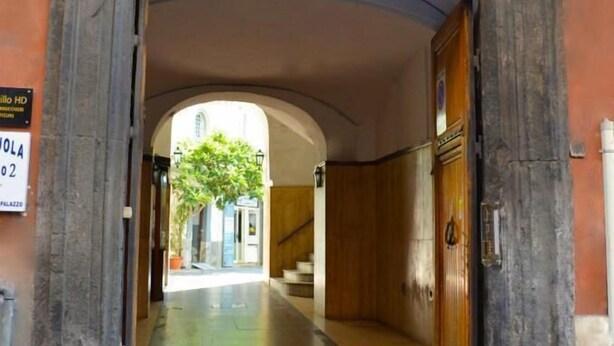 Un ingresso ad arco a un edificio con una insegna che indica un albergo.
