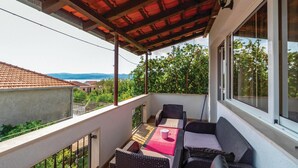 Ein Balkon mit Gartenmöbeln, einer Pergola und Blick auf die Umgebung.