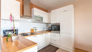 Eine moderne Küche mit weißen Schränken, einer eingebauten Mikrowelle, einem Herd und einem Backofen.