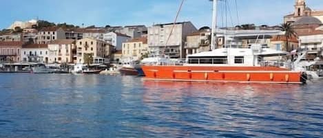 Een haven met een grote oranje boot afgemeerd nabij gebouwen.