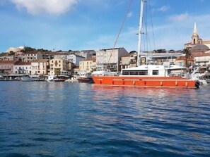 En hamnfront med en stor orange båt som ligger förtöjd nära byggnaderna.