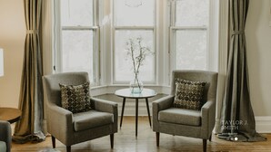 A room with two armchairs, a small round table, and a vase with branches. - Close to everything! DISCOUNTS for Long Stays- Fully Remodeled (Eau Claire)