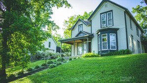 A two-story house with a front porch, a covered entryway, and a well-maintained lawn. - Close to everything! DISCOUNTS for Long Stays- Fully Remodeled (Eau Claire)