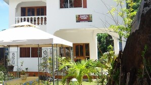 A two-story building with a sign for "Josie's Cottage" and a covered outdoor seating area with a table and chairs.