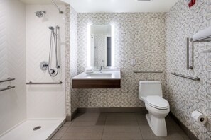 Een badkamer met douche, toilet en wastafel.