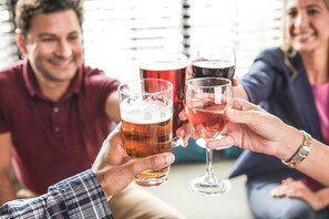 A group of people toasting with glasses of beer in a casual indoor setting.