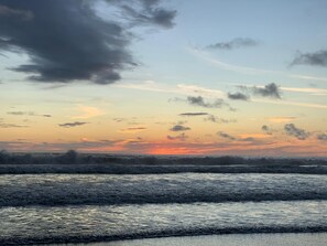 A beach scene with waves and a sunset.