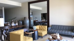Un salon moderne comprenant un canapé, des fauteuils, une table basse et des vases décoratifs.