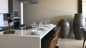 Une cuisine moderne dotée d’un îlot central, d’un four encastré et d’un grand vase.