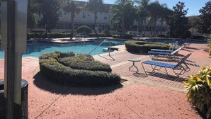 A pool area with lounge chairs and a circular hedge. - It’s only 15 minutes drive to Disney World and the amazing outlets in Orlando (Kissimmee)