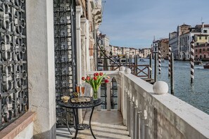 Un balcó amb una taula per a dos, amb vistes a un canal i edificis històrics.