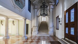 A grand hallway with a checkered floor, a staircase, and a large chandelier. - Ca' Degli Specchi Grand Canal (Venice)