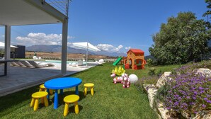 A pool area with a table and chairs, a playhouse, and a slide. - Stunning home in Balestrate (Balestrate)