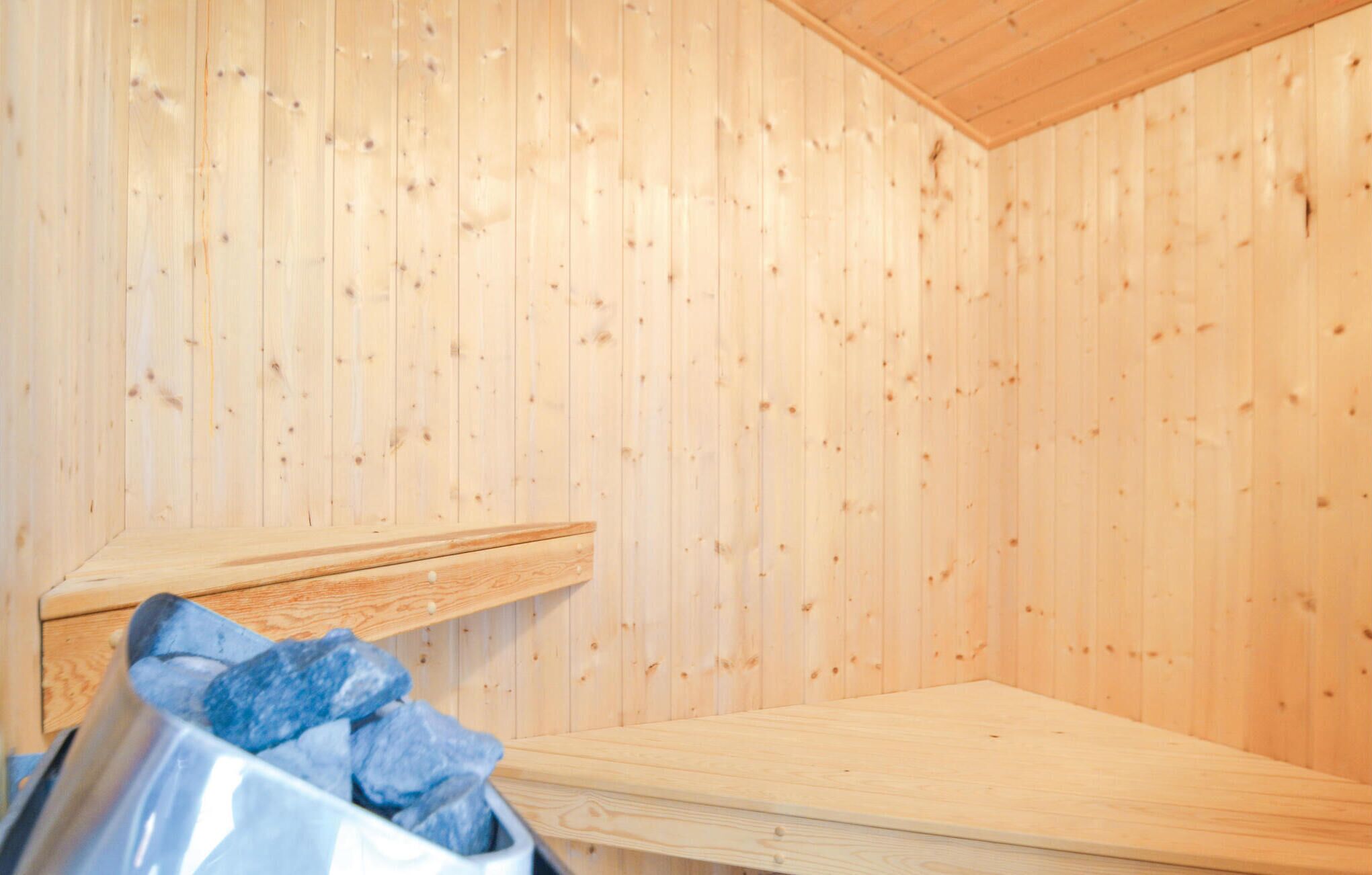 A sauna room with wooden walls and a bench.
