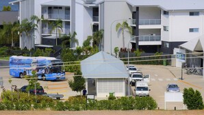 A modern building with multiple balconies, a covered parking area, and a view of the sea. - Spa Haven Deluxe 17A (Airlie Beach)