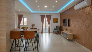 A modern living room with a dining area, featuring a flat-screen TV, a sofa, and a coffee table. - Gorgeous home in Imotski (Imotski)
