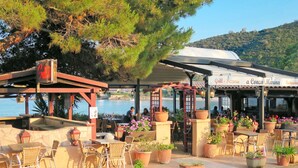 An outdoor dining area with tables and chairs, potted plants, and a covered seating area with a sign reading "Grill - Pizzeria a Conca Marina Restaurant". - Stunning  villa for 6 people with pool, WIFI, A/C, TV and terrace (Tarco)