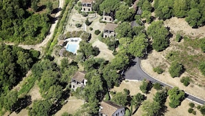 An aerial view of a property with multiple buildings, a swimming pool, and a winding road. - Lovely apartment for 10 people with A/C, WIFI, pool, TV, patio, pets allowed and panoramic view (Pierraggi)