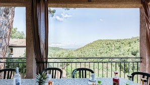 A table set with breakfast items including bread, fruits, and beverages, overlooking a scenic hillside view. - Lovely apartment for 10 people with A/C, WIFI, pool, TV, patio, pets allowed and panoramic view (Pierraggi)