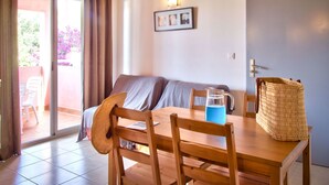 Une pièce chaleureuse avec une table en bois, des chaises, un canapé et un panier en osier.