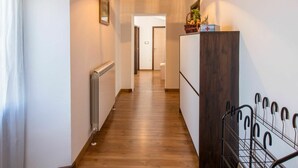 A hallway with wooden flooring, a radiator, a wooden cabinet with a red cross sign, and a metal rack. - Stunning private villa for 6 people with private pool, A/C, WIFI, TV and terrace (Pazin)