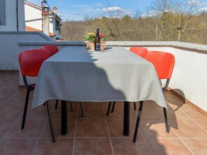 A terrace with a table set for two, surrounded by red chairs, and a bottle of wine on the table. - Stunning private villa for 6 people with private pool, WIFI, A/C, TV and terrace (Pazin)