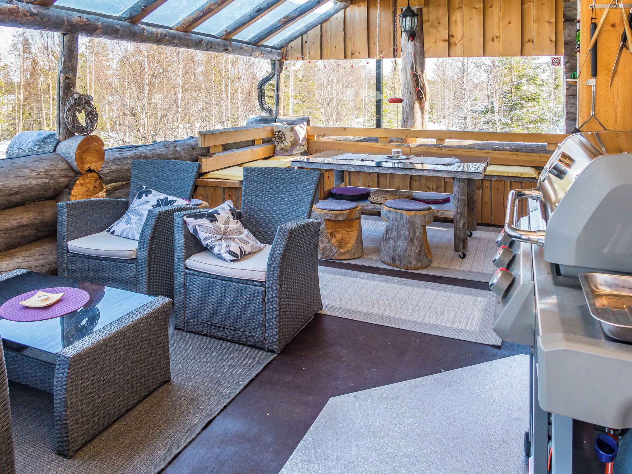 An outdoor seating area with wicker furniture, a table, and a grill.
