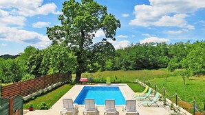 A rectangular swimming pool with a wooden deck, surrounded by lounge chairs and a table. - Beautiful private villa for 8 guests with A/C, internet, private pool, TV, terrace and pets allo... (Buzet)