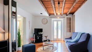 A living room with a wooden ceiling, a sofa, a TV, and a clock on the wall. - Wonderful  villa for 8 people with A/C, WIFI, TV, terrace and pets allowed (Umag)
