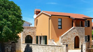 A two-story building with a stone facade, a red-tiled roof, and a small balcony. - Beautiful private villa for 7 guests with A/C, WIFI, TV, terrace and pets allowed (Umag)
