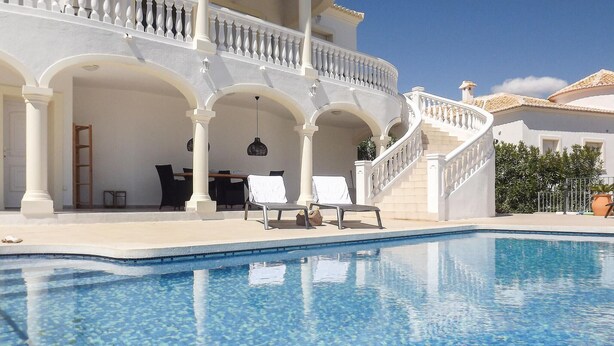 A poolside area with a white building, a staircase, and lounge chairs. - Beautiful home in Trullent (Trullent)