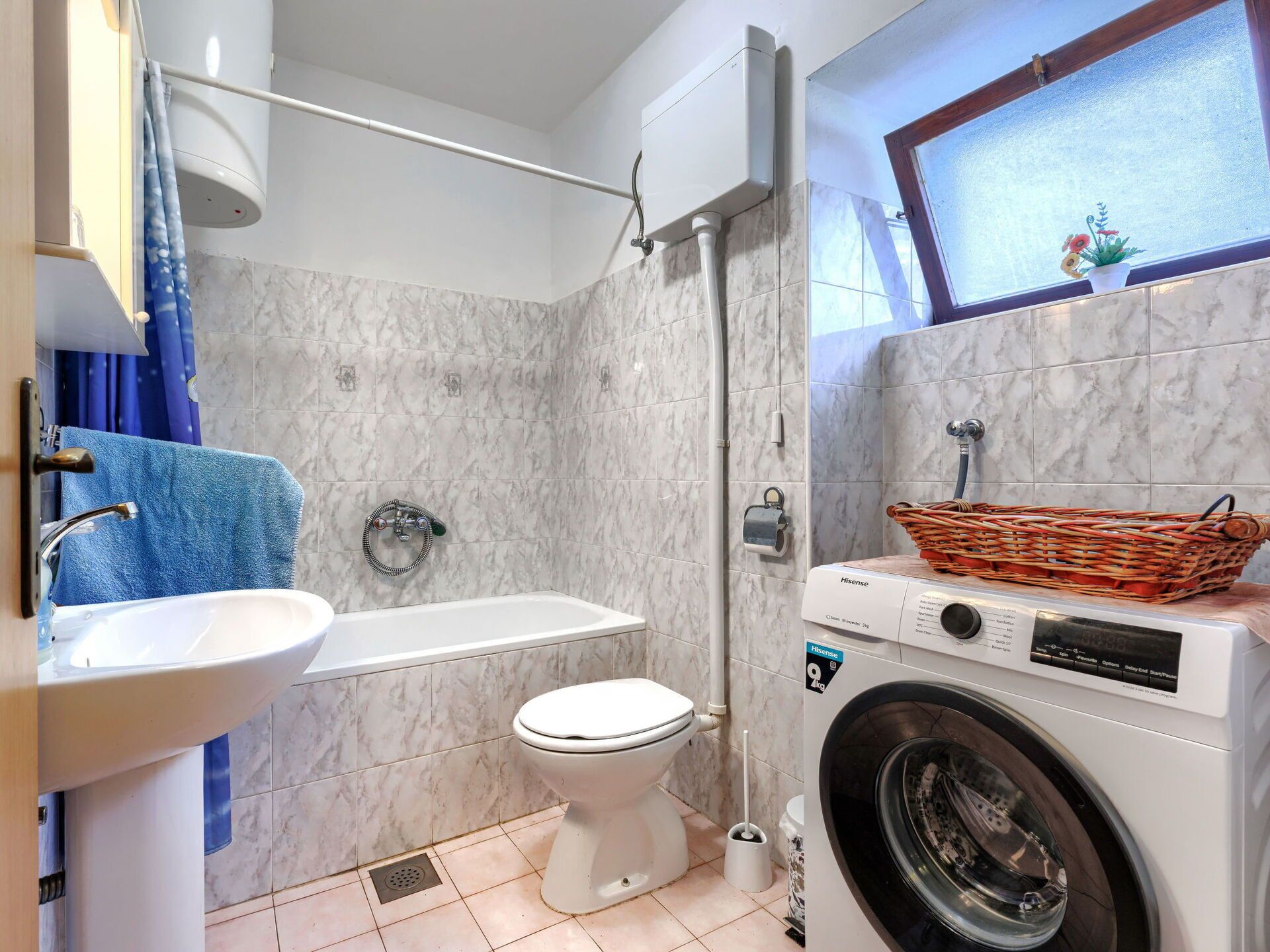 Un bagno dotato di vasca, water, lavandino e lavatrice.