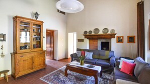 Un salon avec une cheminée, un meuble en bois, un canapé et une table basse.