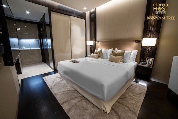 Relax in a serene space with a large bed, bedside table, and comfortable seating area.