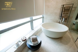 Bathroom features a bathtub, a stool, and a mirror.