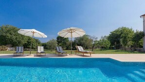 Una piscina con sillas de descanso y sombrillas.