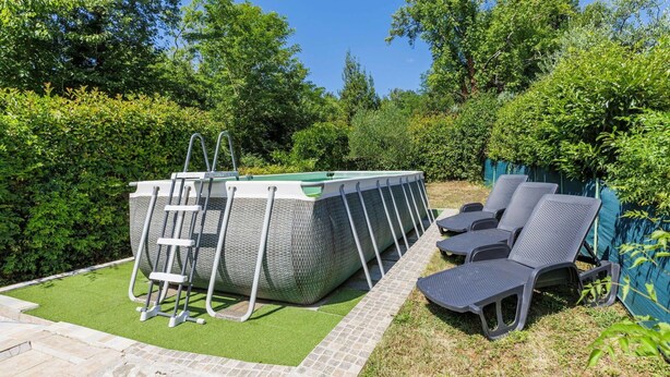 A swimming pool with a ladder, surrounded by a stone pathway, and adjacent to lounge chairs. - Stunning  villa for 6 people with WIFI, private pool, A/C, TV, terrace and pets allowed (Pazin)