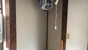 Un farol tradicional japonés con caracteres japoneses colgando de una viga de madera.