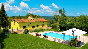 A yellow villa with a swimming pool, surrounded by a well-maintained lawn and trees. - Beautiful private villa for 7 people with WIFI, A/C, private pool, TV and patio (Pazin)