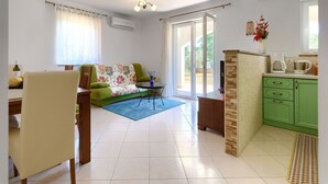 A living room with a sofa, a coffee table, and a dining area with chairs. There is a kitchen area with a stove and cabinets. - Wonderful private villa for 6 people with WIFI, A/C, private pool, TV and terrace (Labin)