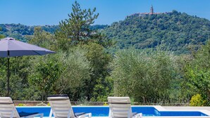A pool area with lounge chairs and an umbrella, overlooking a hill with a tower. - Wonderful private villa for 6 people with WIFI, A/C, private pool, TV and terrace (Labin)